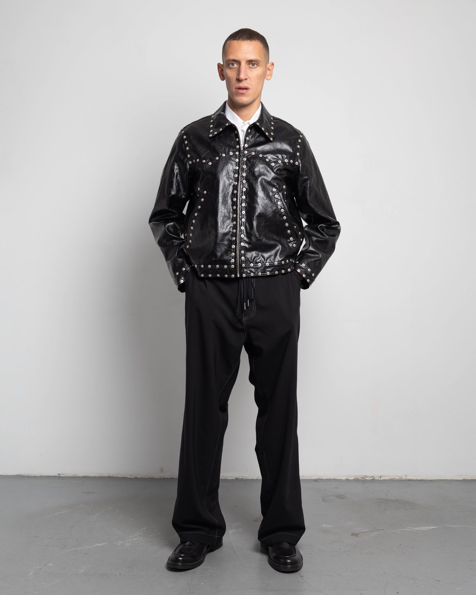 THE ZIPPED STUDDED JACKET IN BLACK FAUX LEATHER