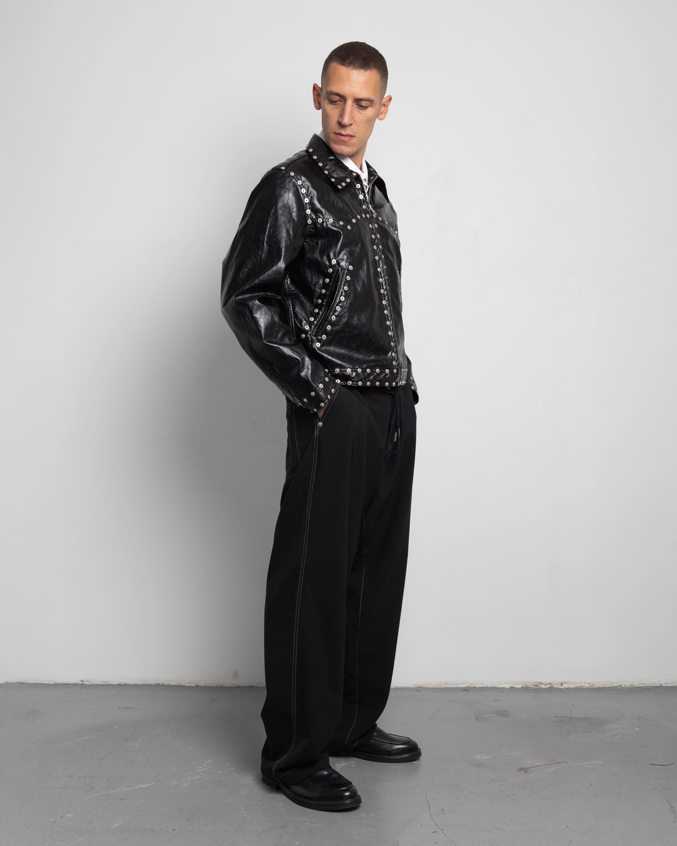 THE ZIPPED STUDDED JACKET IN BLACK FAUX LEATHER