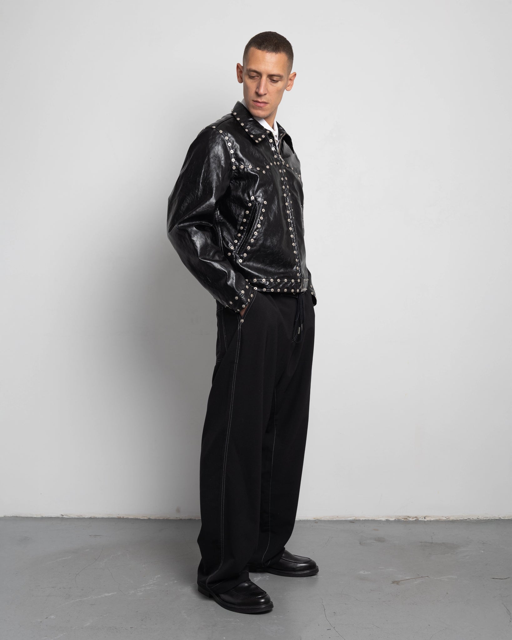 THE ZIPPED STUDDED JACKET IN BLACK FAUX LEATHER