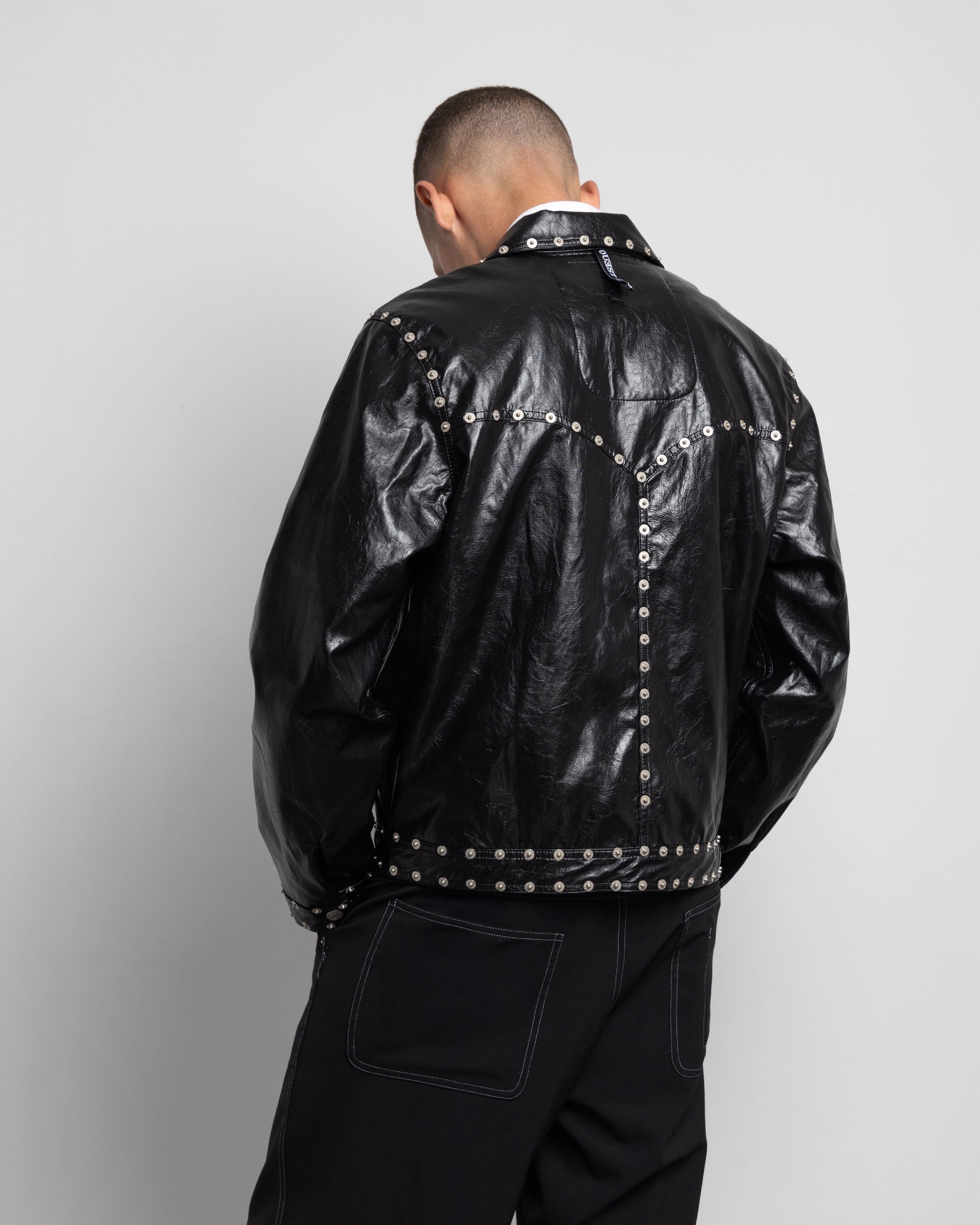 THE ZIPPED STUDDED JACKET IN BLACK FAUX LEATHER