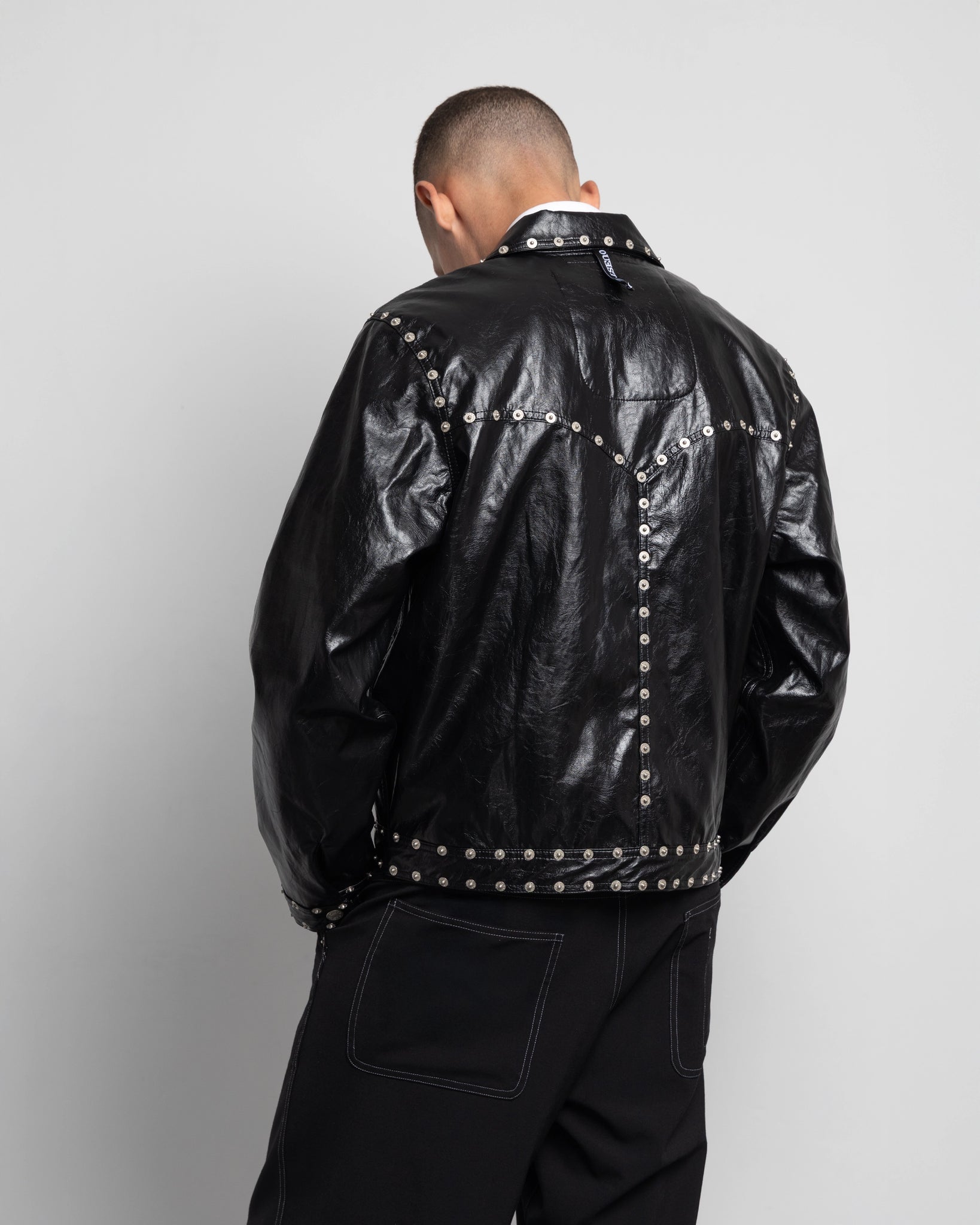 THE ZIPPED STUDDED JACKET IN BLACK FAUX LEATHER