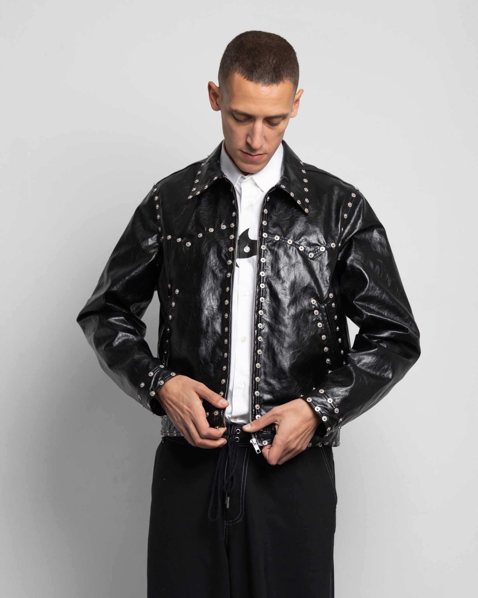 THE ZIPPED STUDDED JACKET IN BLACK FAUX LEATHER